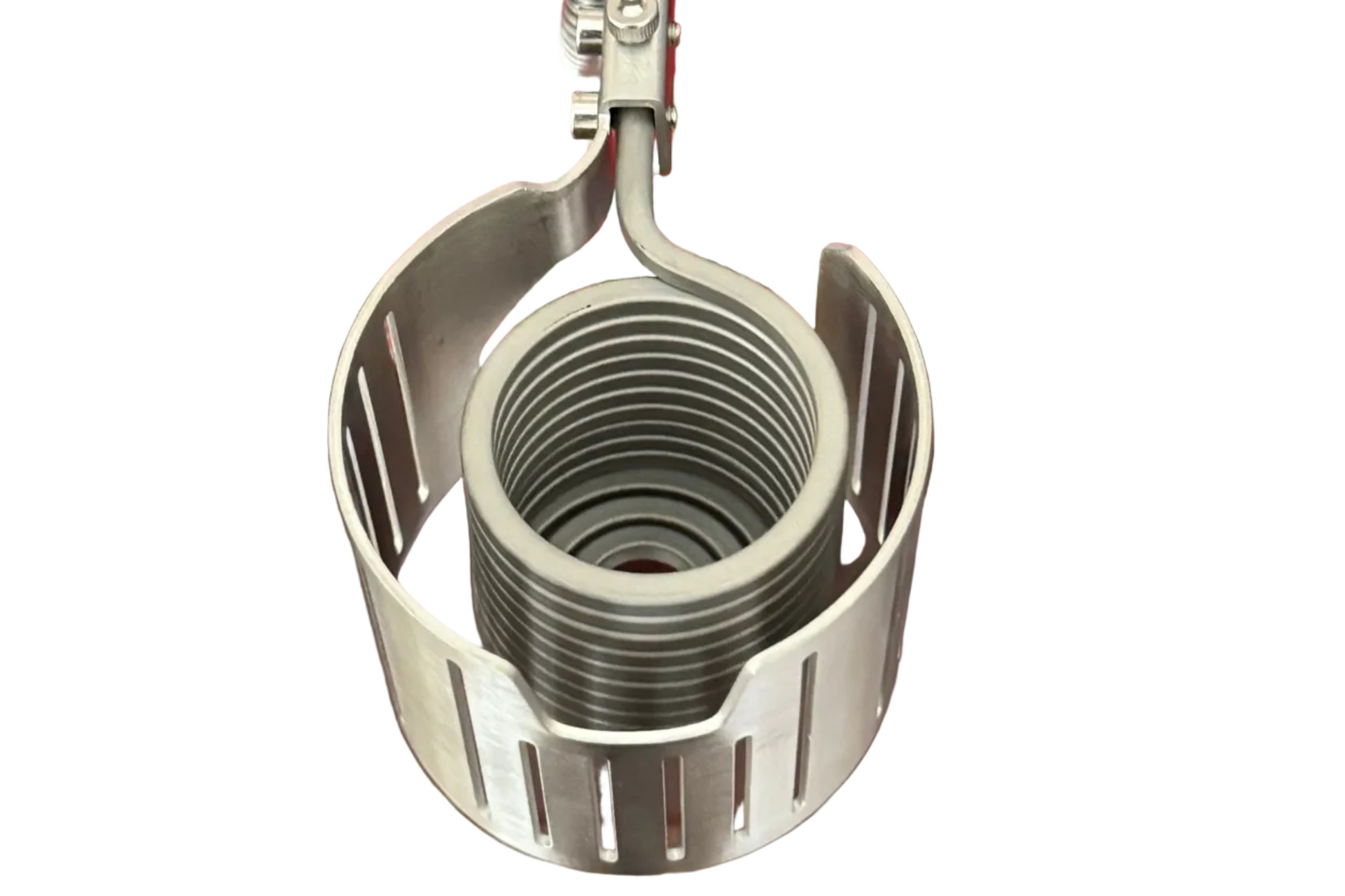 A stainless steel medical-style clamp or holder with a coiled spring inside a slotted metal frame, mounted on a red rectangular device, photographed on a dark wooden tabletop.